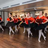 Donne in abiti da balletto nero e rosso, con ventagli, pronte a fare danza.