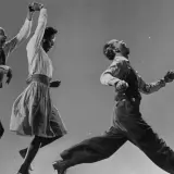 Coppia balla il lindy hop con energia e gioia, in un'esplosione di movimento e ritmo.