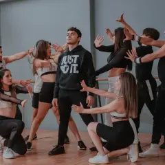 Un gruppo di giovani ballerini in un ipop ballo, con un ragazzo al centro che indossa una felpa "Just Do It".