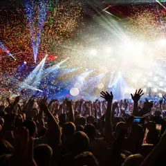 Festa con coriandoli e luci abbaglianti, perfetta per le canzoni per compleanno amica. La folla esulta, creando un'atmosfera magica.