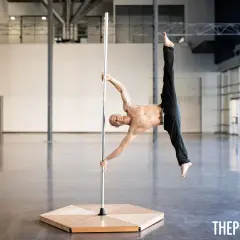 Uomo in posa acrobatica su un palo, dimostra che anche i pole dance principianti possono raggiungere incredibili posizioni con la giusta dedizione.