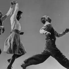 Coppia balla il lindy hop con energia e gioia, in un'esplosione di movimento e ritmo.