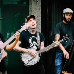 Un trio suona musica con chitarra, banjo e contrabbasso. Le loro canzoni tonalità bassa creano un'atmosfera suggestiva.