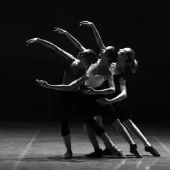 Tre ballerine in posa aggraziata durante lezioni di danza, con le braccia tese e i corpi in movimento.