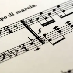 Spartito musicale con indicazione "Tempo di marcia". Le note suggeriscono un ritmo deciso, un tempo tagliato per una marcia solenne.