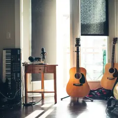 Un angolo per creare la tua prossima **scala canzone**: chitarre, basso, tastiera, microfono e cuffie, pronti per la musica.