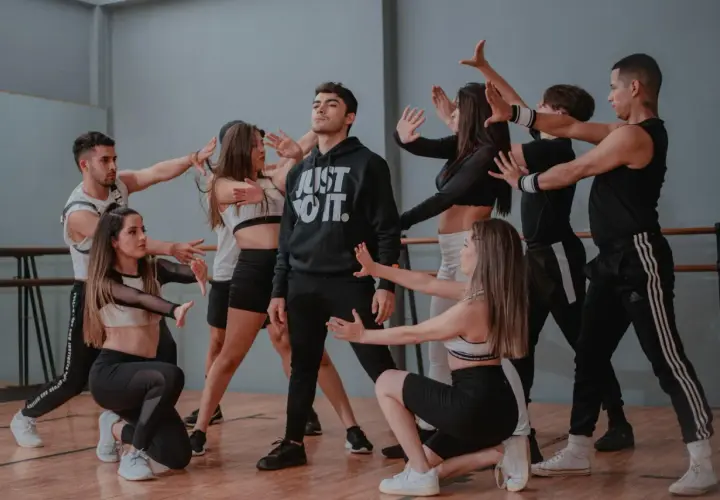 Un gruppo di giovani ballerini in un ipop ballo, con un ragazzo al centro che indossa una felpa "Just Do It".