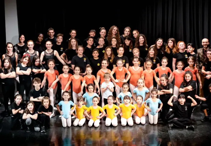 Un gruppo di giovani ballerini posa per una foto di gruppo dopo i loro corsi hip hop.