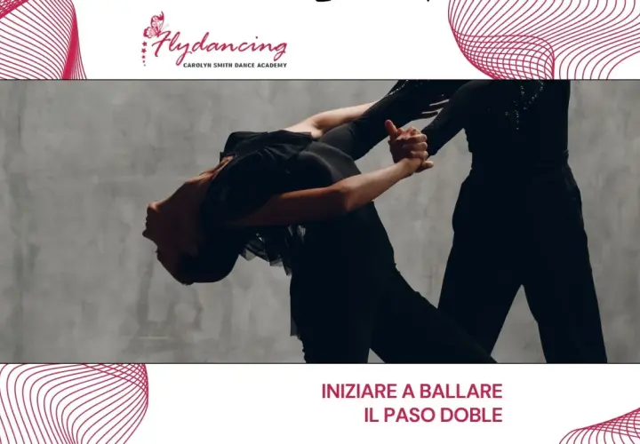 Two dancers in black outfits perform a dramatic Paso Doble pose against a grey backdrop.