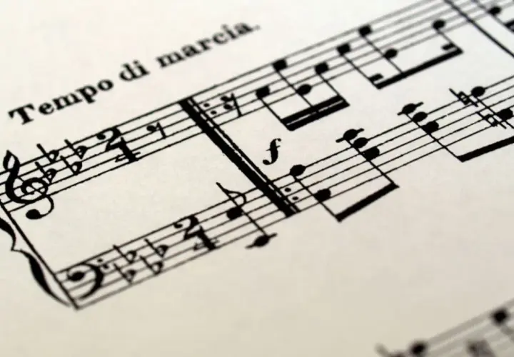 Spartito musicale con indicazione "Tempo di marcia". Le note suggeriscono un ritmo deciso, un tempo tagliato per una marcia solenne.