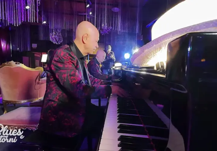 Pianista con giacca fiorata suona la canzone blues più famosa, accompagnato da un altro musicista.