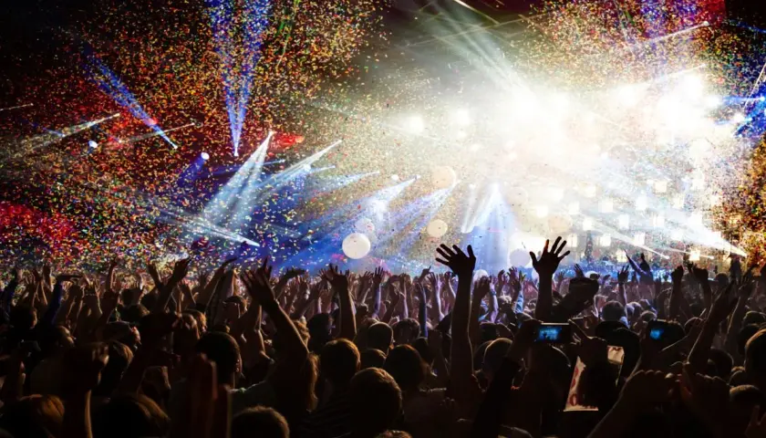 Festa con coriandoli e luci abbaglianti, perfetta per le canzoni per compleanno amica. La folla esulta, creando un'atmosfera magica.