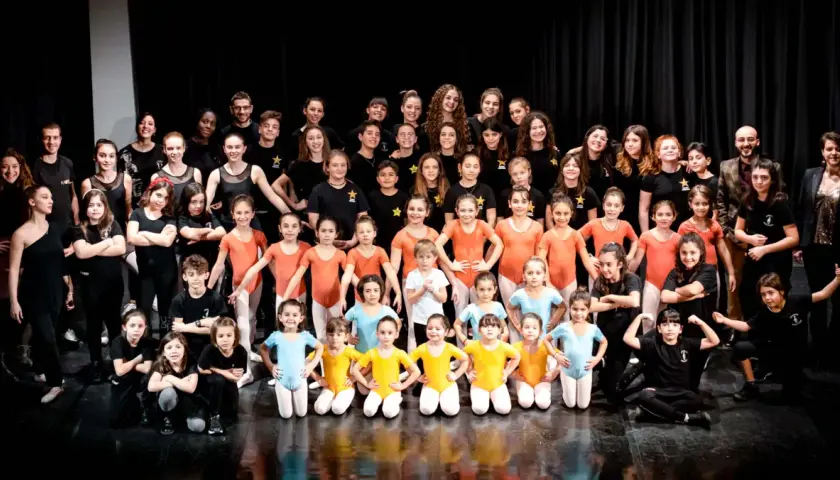 Un gruppo di giovani ballerini posa per una foto di gruppo dopo i loro corsi hip hop.