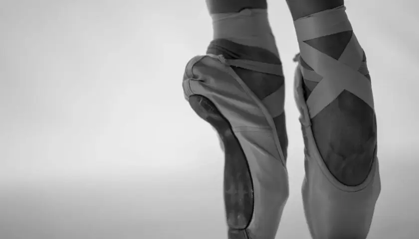 Punte danza classica in primo piano, con nastri incrociati che definiscono la caviglia.