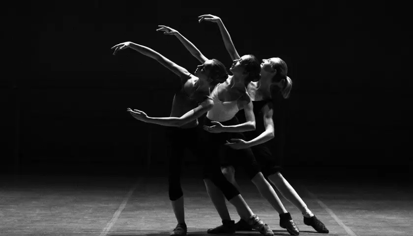 Tre ballerine in posa aggraziata durante lezioni di danza, con le braccia tese e i corpi in movimento.