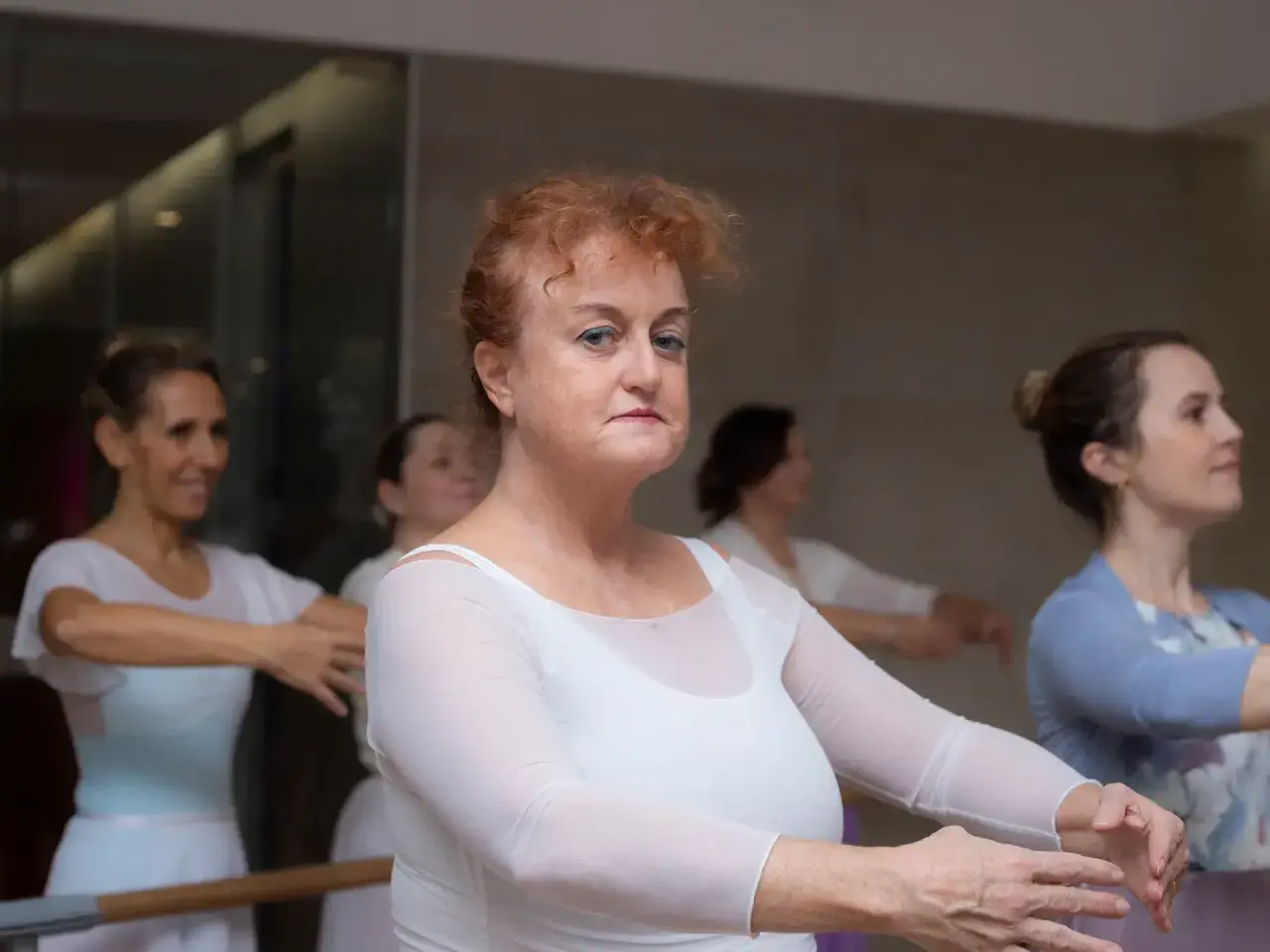 Donne adulte in posa di danza classica, con grazia e concentrazione, imparano i passi con passione.