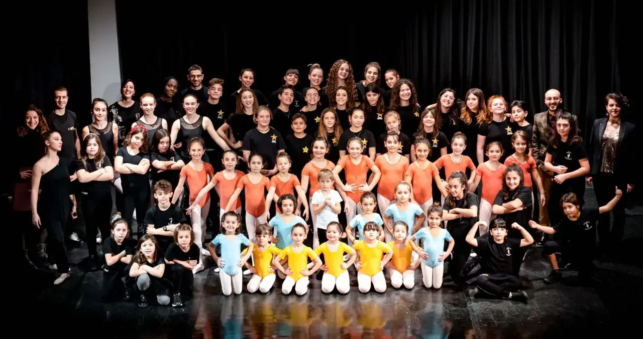 Un gruppo di giovani ballerini posa per una foto di gruppo dopo i loro corsi hip hop.
