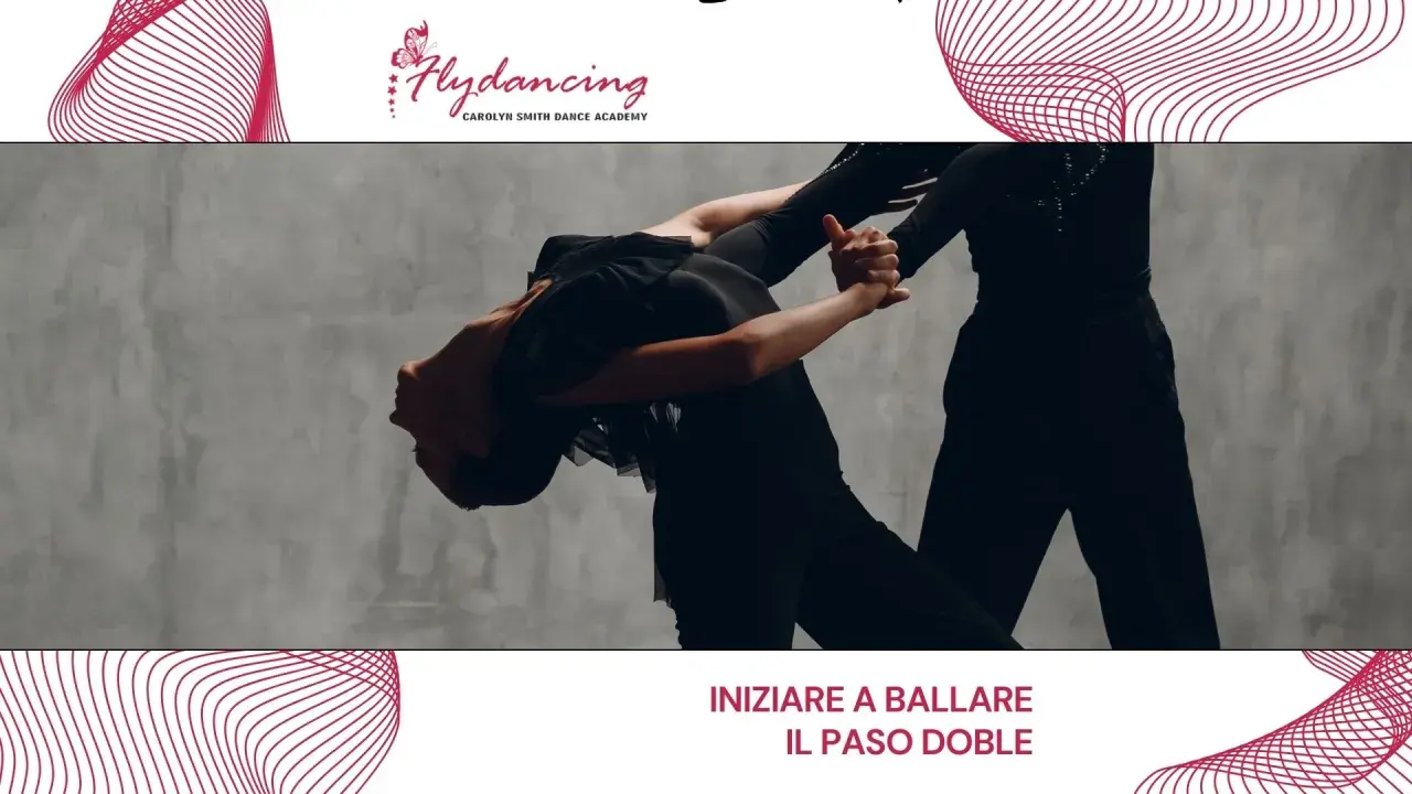 Two dancers in black outfits perform a dramatic Paso Doble pose against a grey backdrop.