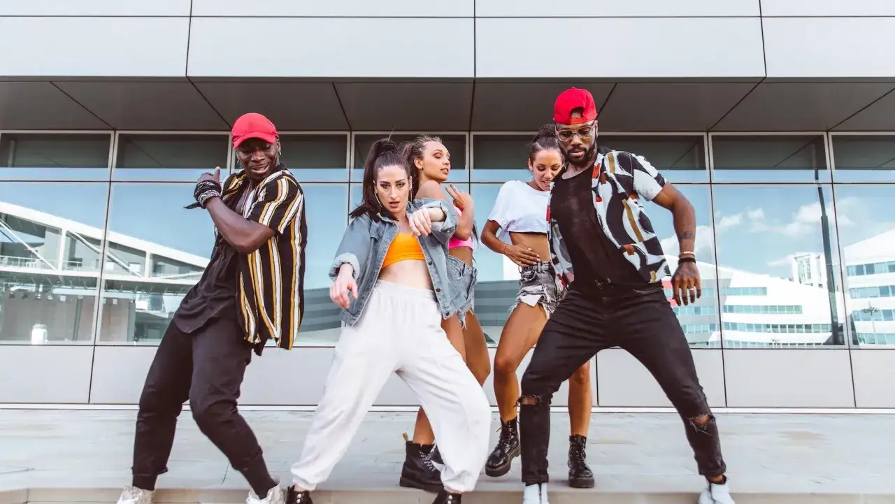Un gruppo di ballerini esegue un ipop ballo davanti a un edificio moderno.