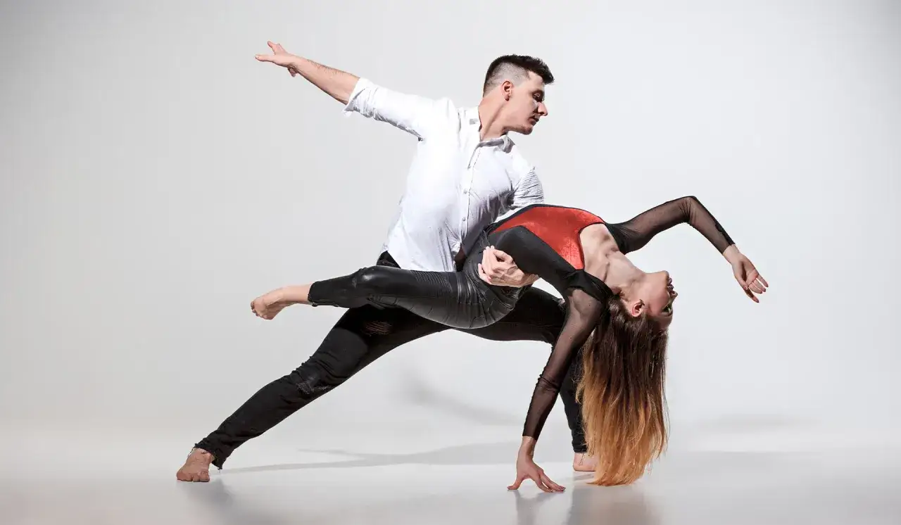 Coppia in un dinamico paso doble ballo di coppia, con lei piegata all'indietro e lui che la sorregge con passione.