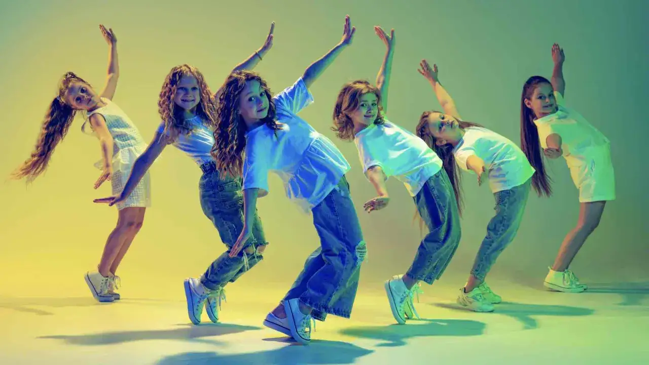 Bambine in posa dinamica, un gruppo di giovani ballerine che eseguono una energica danza hip hop con movimenti coordinati e sorrisi contagiosi.
